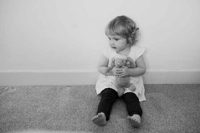 little girl sitting with toy rabbit