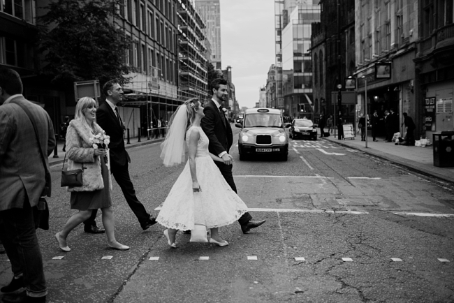 bride and groom crossing road in manchester