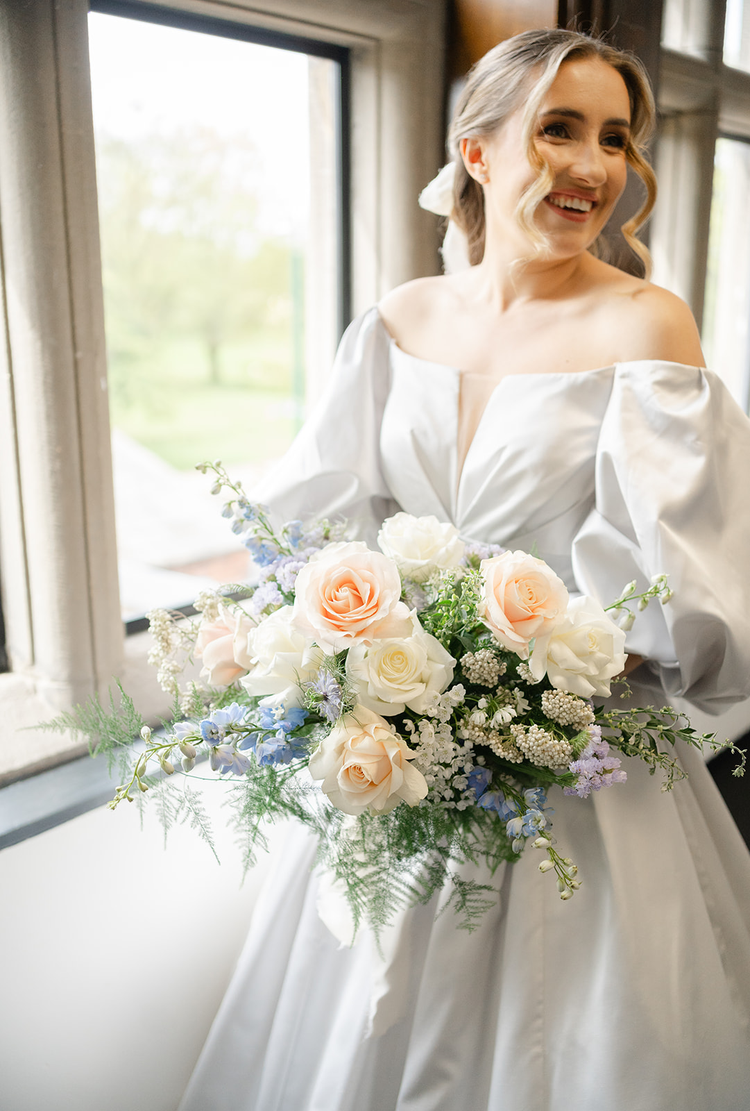 bride in pale blue dress holding bouquet