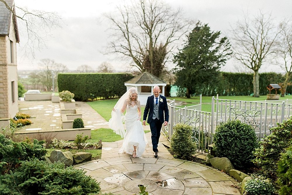 bride and groom walking in the garden at west tower in winter