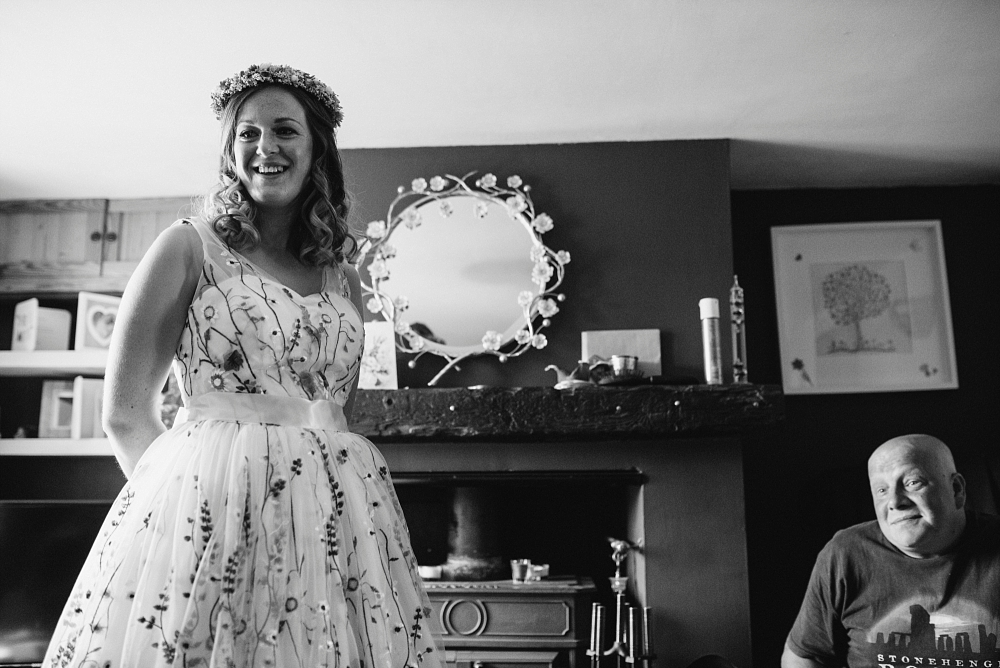 bride with flower crown and floral dress with her dad at home