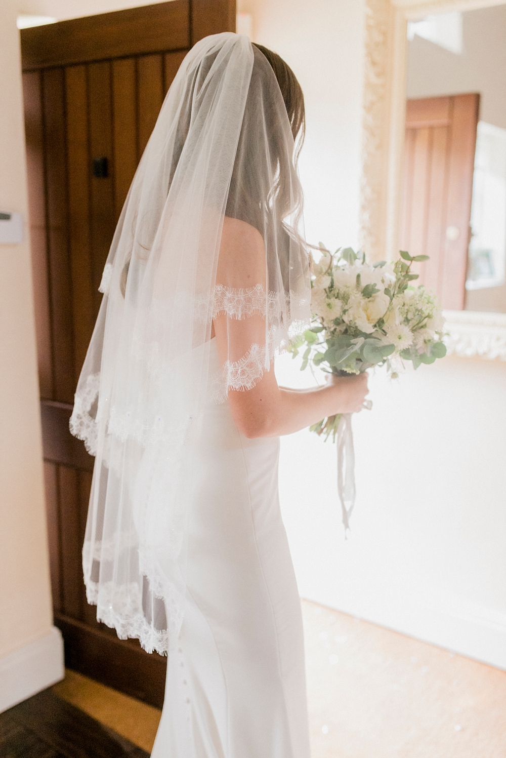 bride with lace veil and simple, classic dress
