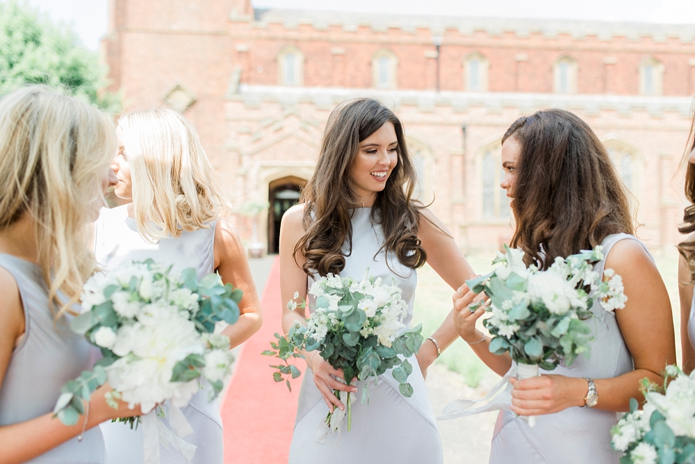 bridesmaids with bouquets in the sunshine outside church