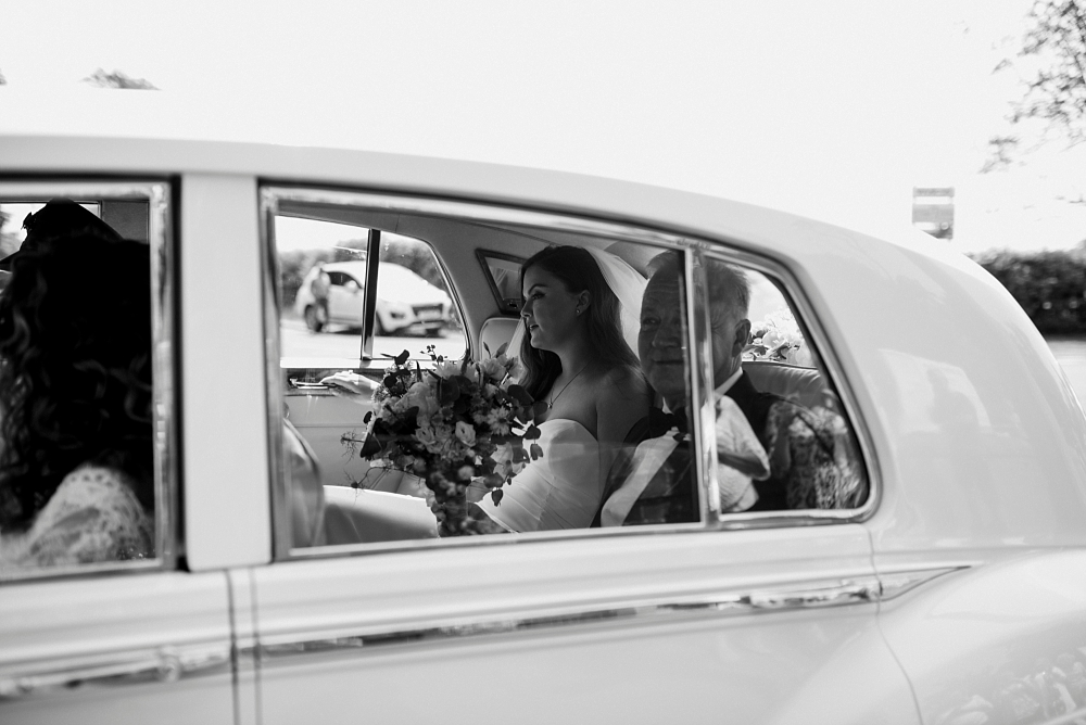 bride and her dad arrive at church in wedding car