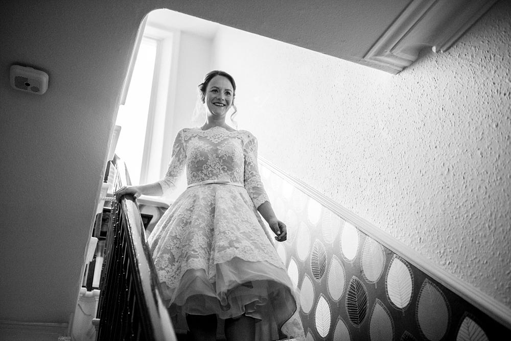 bride walks down stairs at parents home