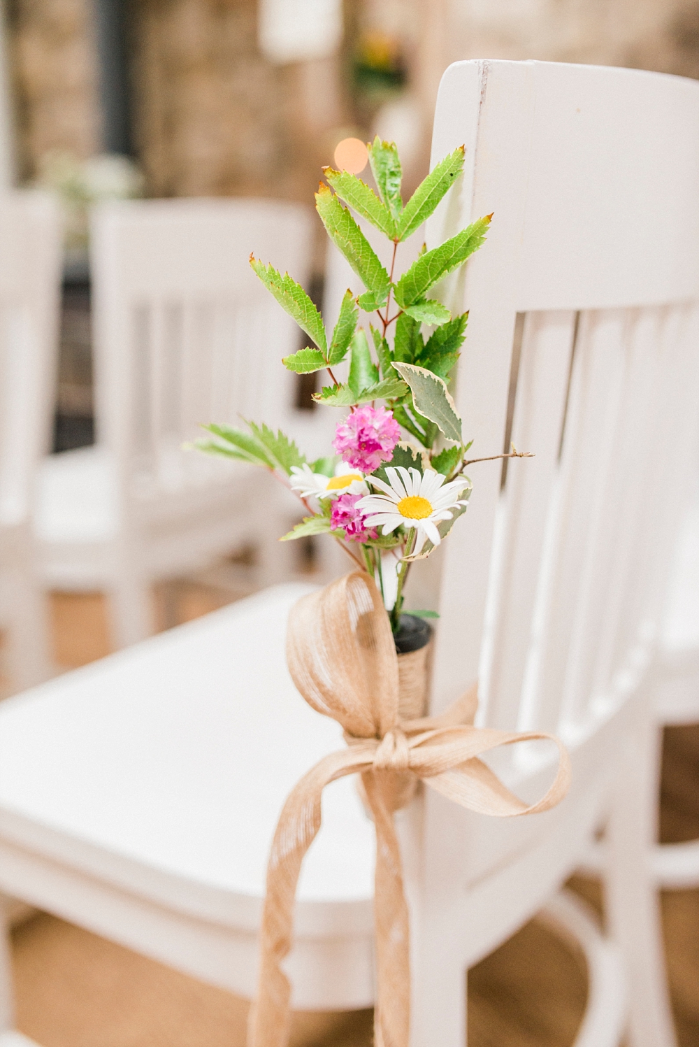 flowers on chairs at wedding ceremony