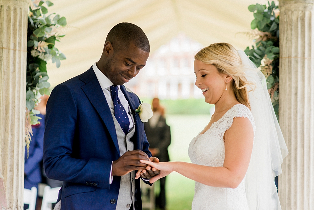 groom putting ring on brides finger at Arlington house wedding