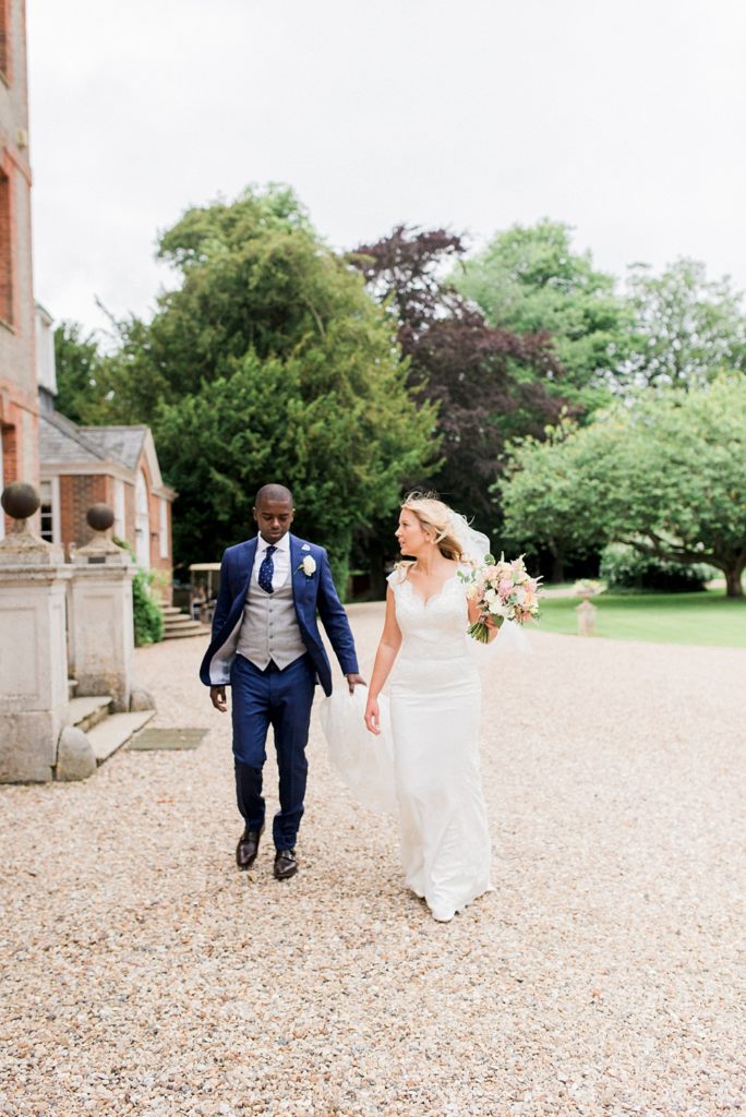 bride and groom walk across courtyard at Ardington House