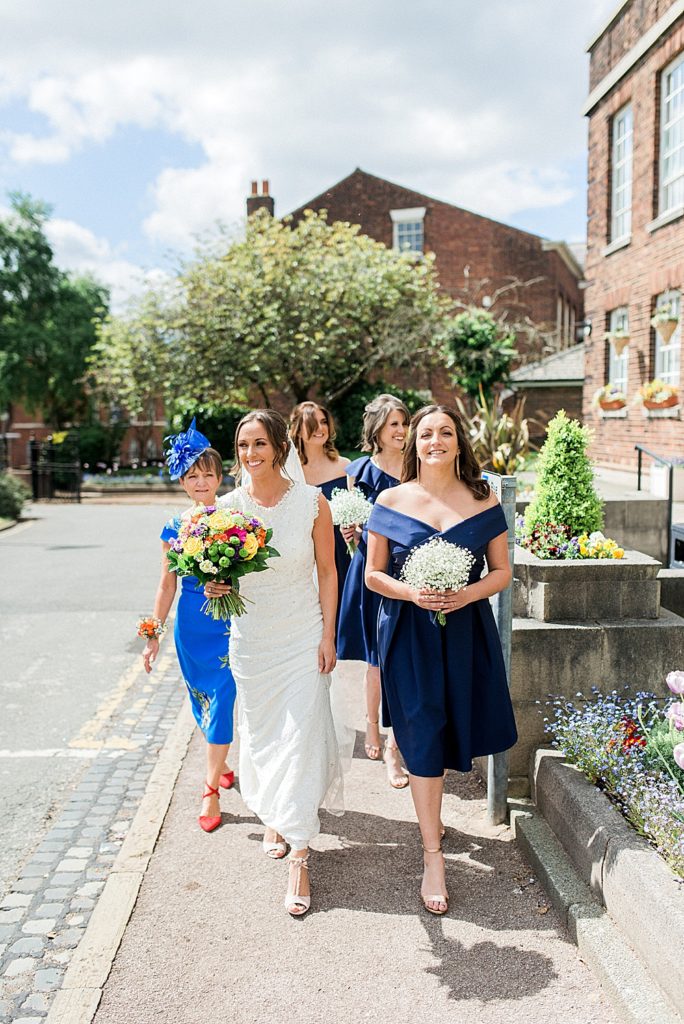bride and her mum and bridesmaids walking into Knowsley registry office garden