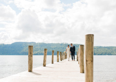 bride and groom on jetty at lake Windermere