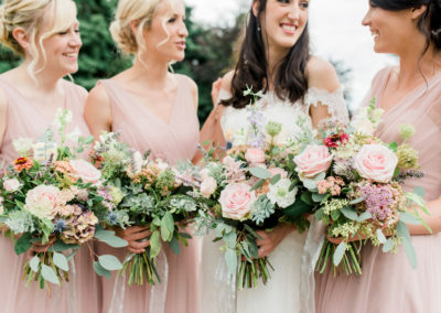 bridesmaids holding bouquets with pink flowers