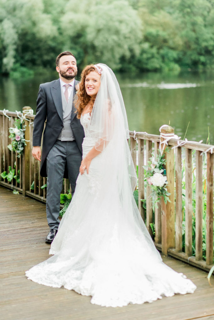 bride with ginger hair with her new husband by lake