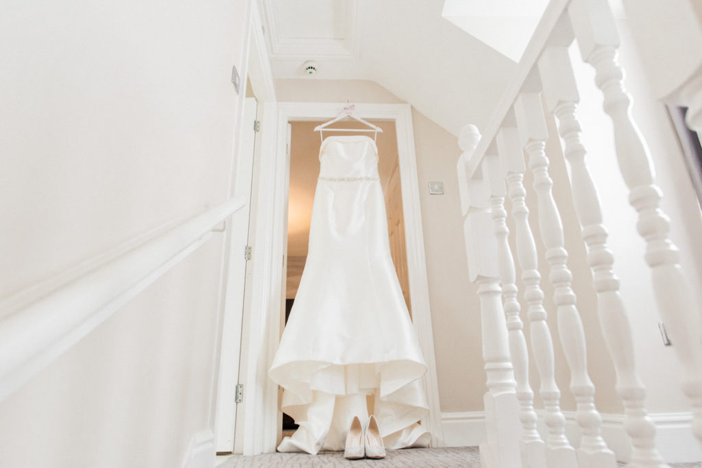 wedding dress hanging in doorway at Walton hall