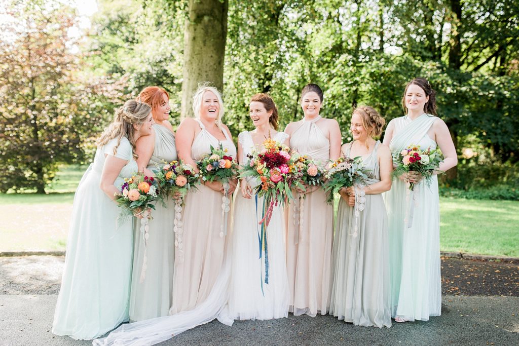 bride and bridesmaids with colourful bouquets and pastel dresses