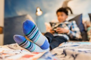 boy in blue socks on bed
