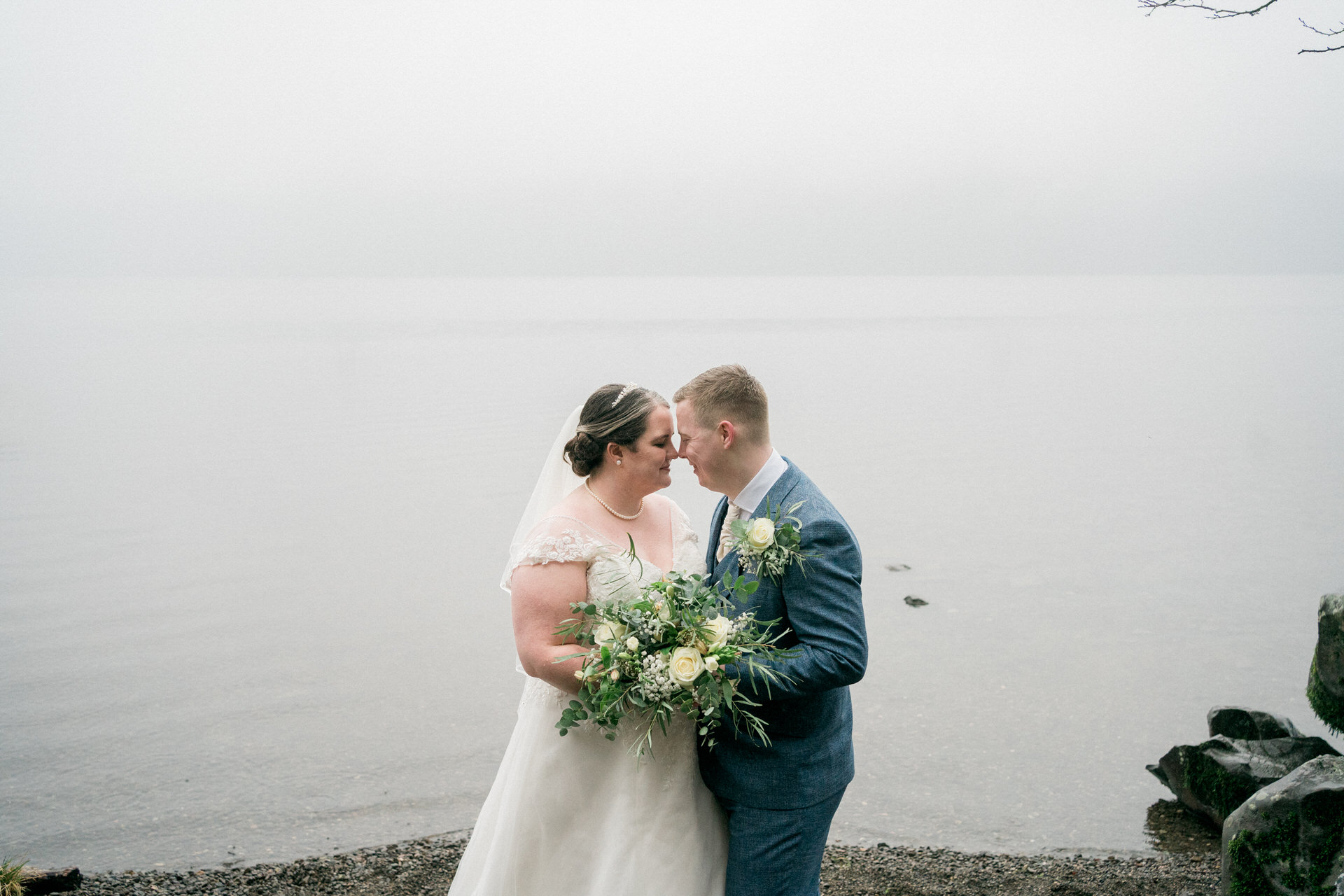 bride and groom by lake windermere