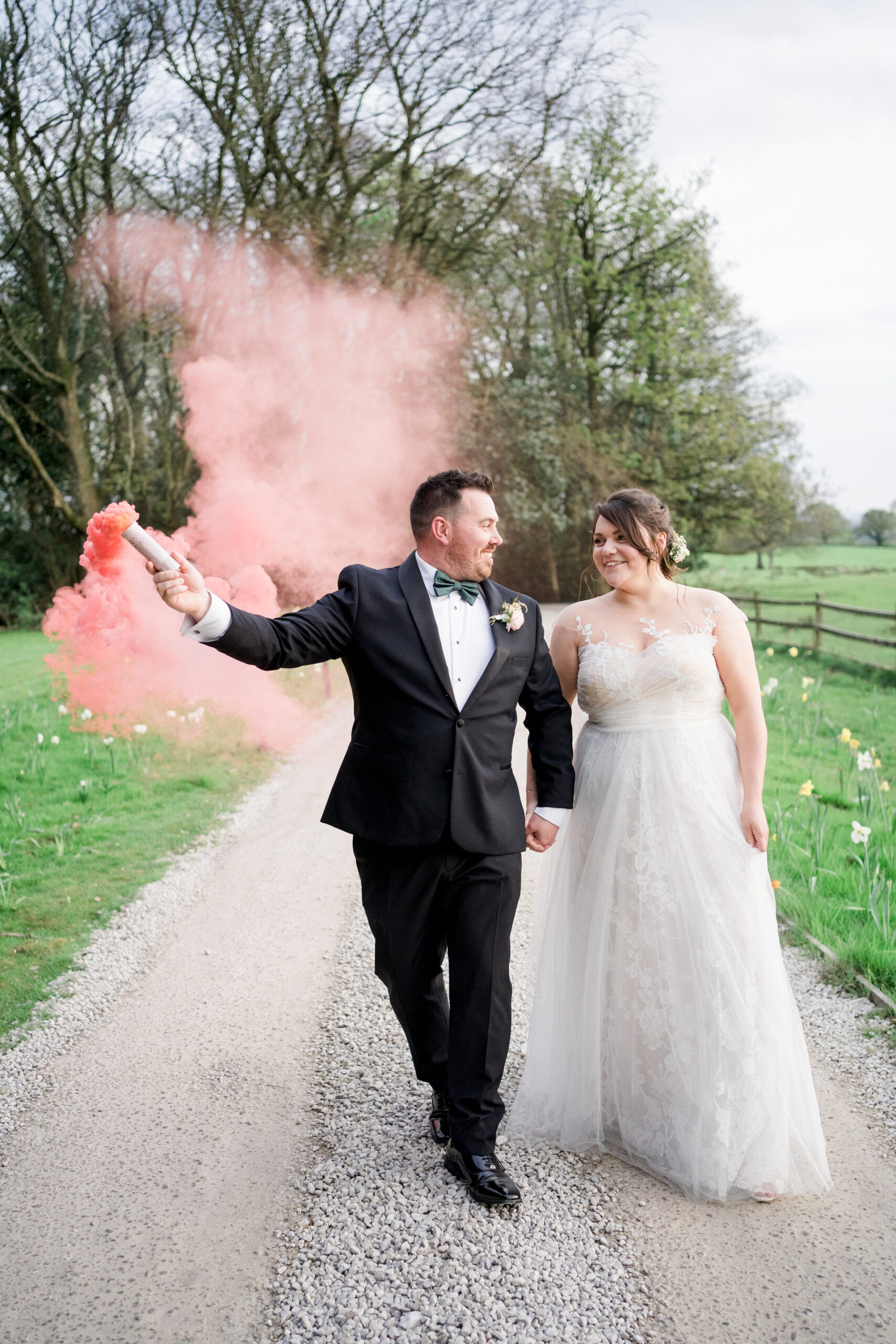 bride and groom with pink smoke bomb at wyresdale park wedding