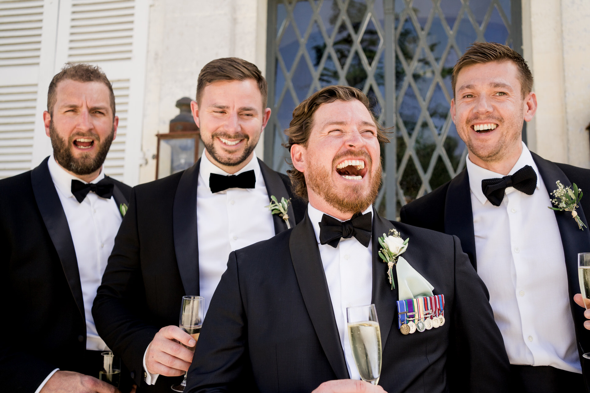 groomsmen laughing at chateau de brives wedding