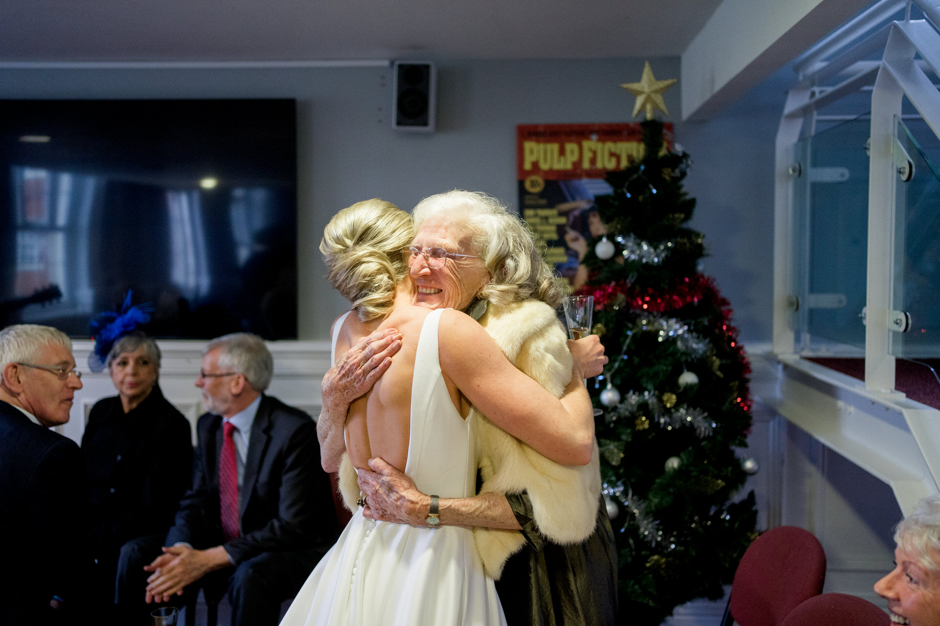 bride hugging grandma by Christmas tree