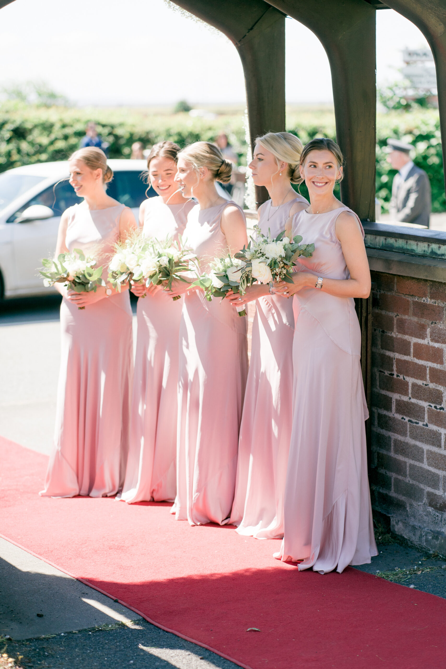 bridesmaids in blush waiting outside st cuthberts church in lytham