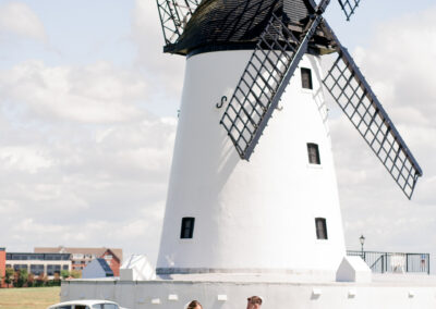 bride and groom walking at the windmill in lytham