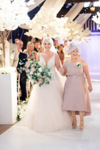 brde and her mum walk down the aisle at Rivington Barn wedding