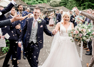bride and groom in confetti tunnel at elegant Rivington Barn wedding