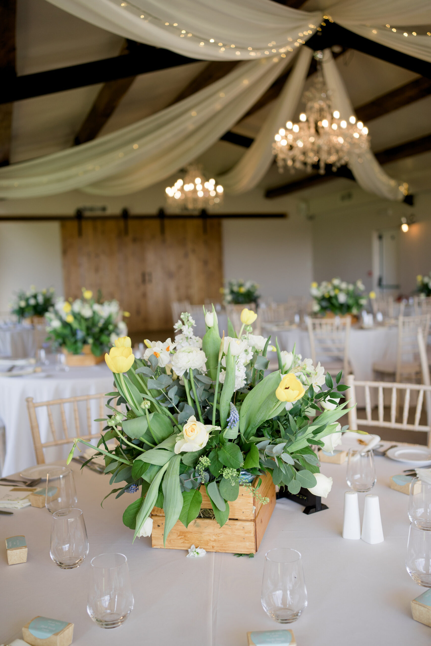 spring flowers in wooden crate as centrepiece for Hyde bank farm wedding