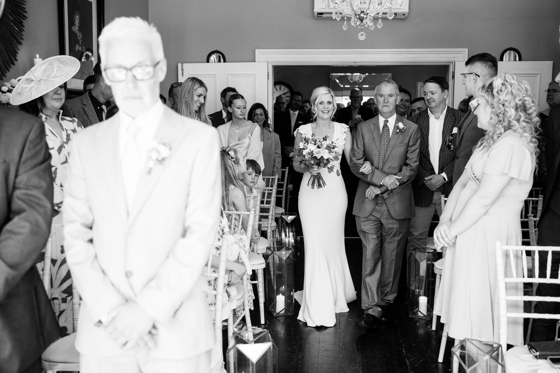 father of the bride has tears in his eyes as he walks daughter down the aisle at didsbury house hotel 