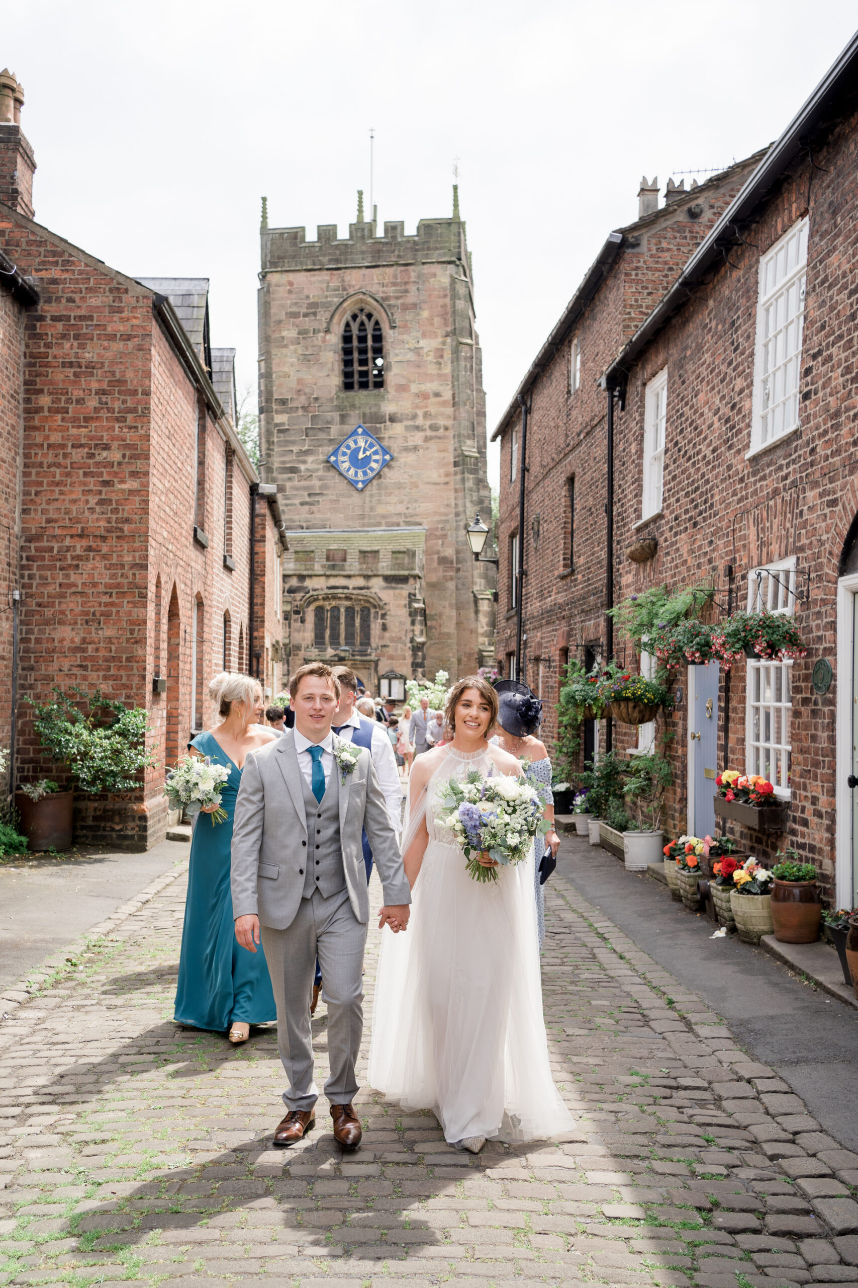 bride and groom walking down the lane at trinity st Michaels church in croston