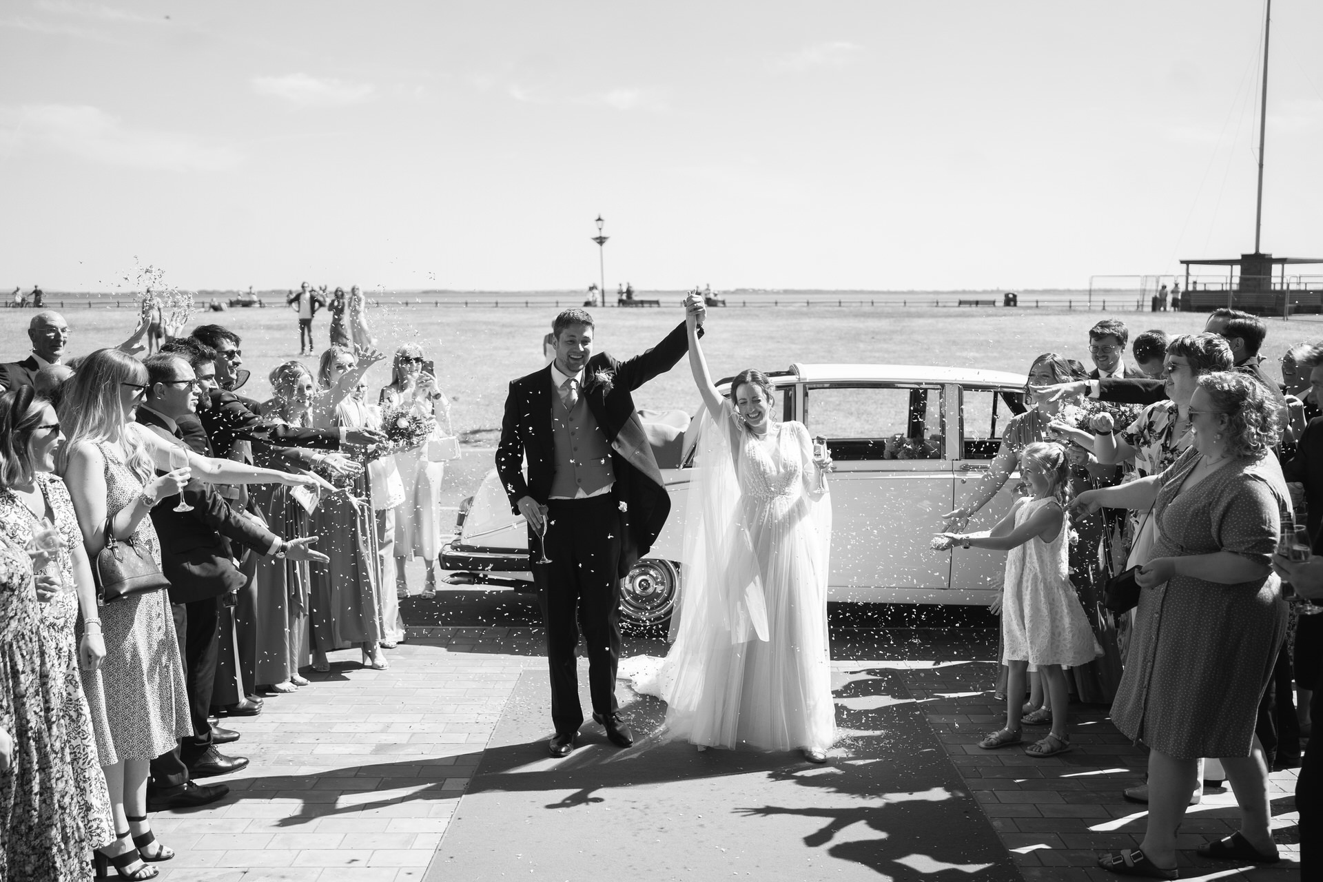 black and white photograph of bride and groom arriving at the Clifton Arms in lytham, being showered with confetti.