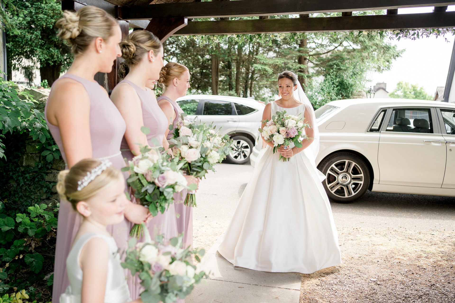 Bride arriving at church at st johns in Levens, greeted by her bridesmaids