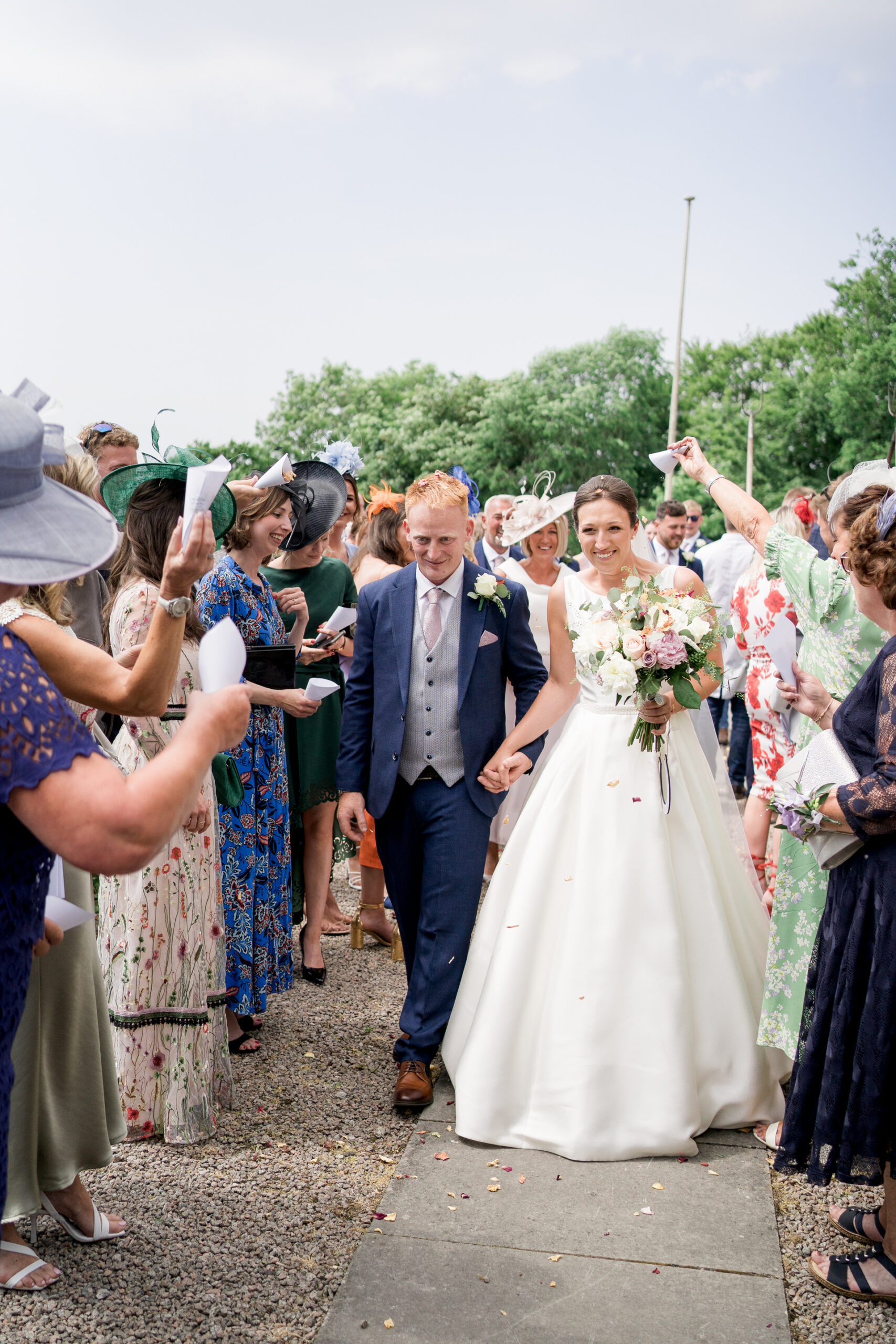 bride and groom walk through guests throwing confetti