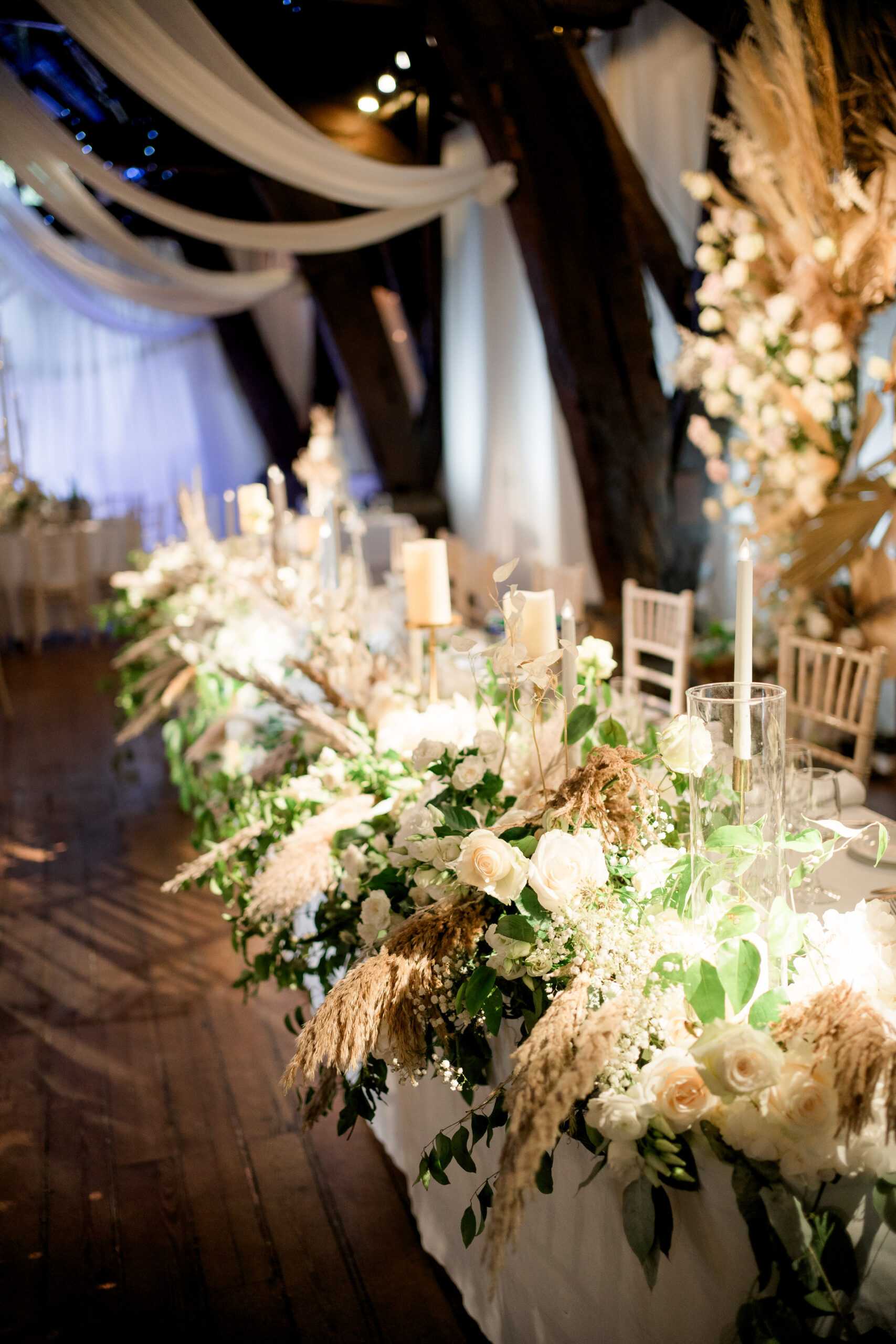 wedding flowers along the top table at Rivington hall barn