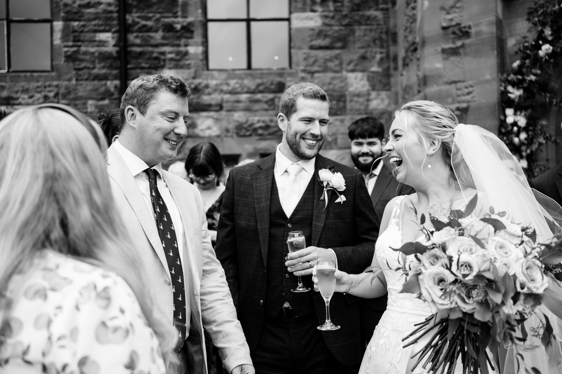 documentary wedding photograph at peckforton castle. bride and groom talk to guests