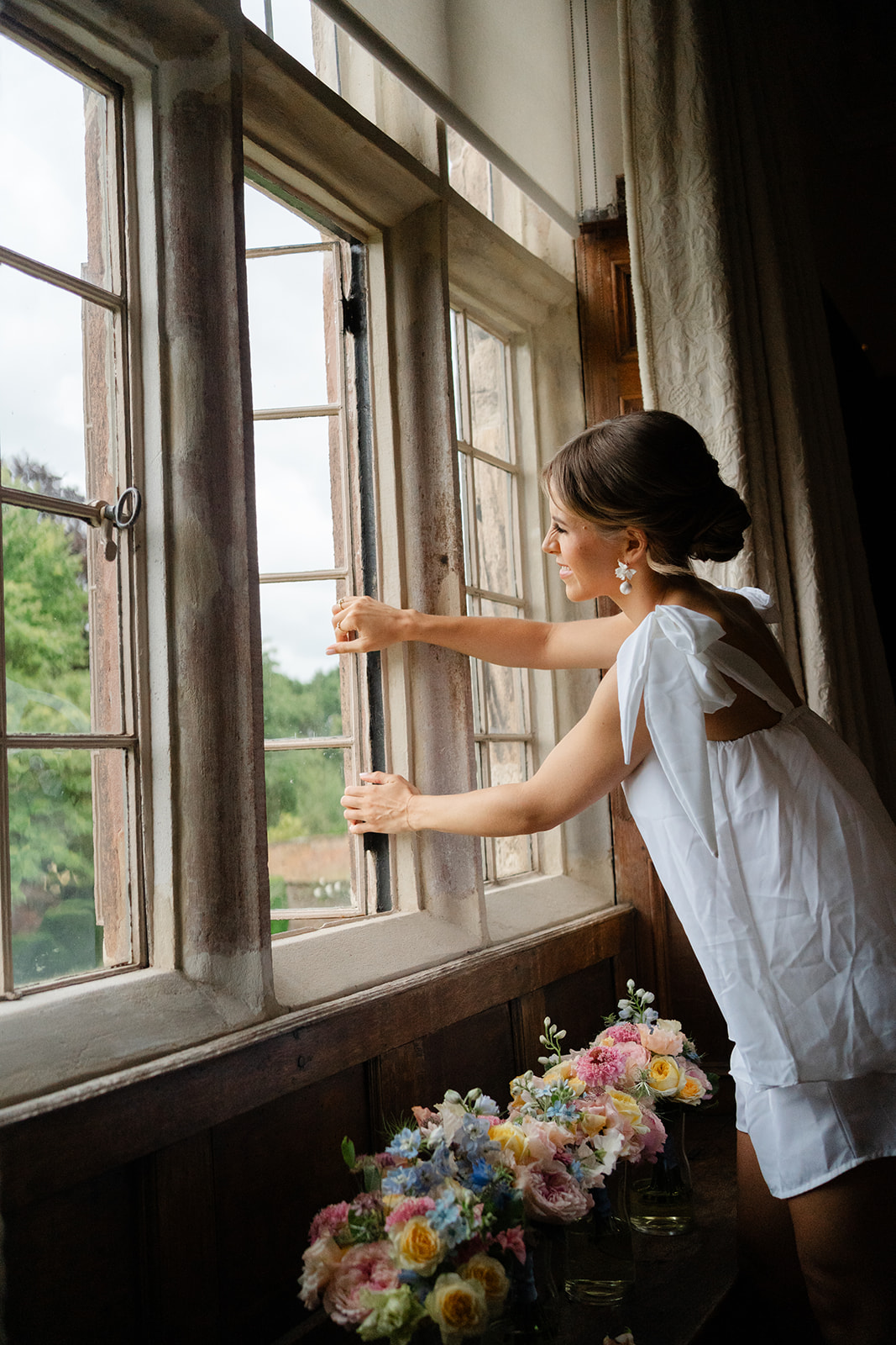 bride peeping through the window from the dressing room at Dorfold Hall