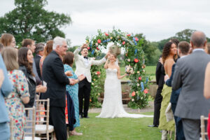 bride and groom celebrate at the top of the aisle