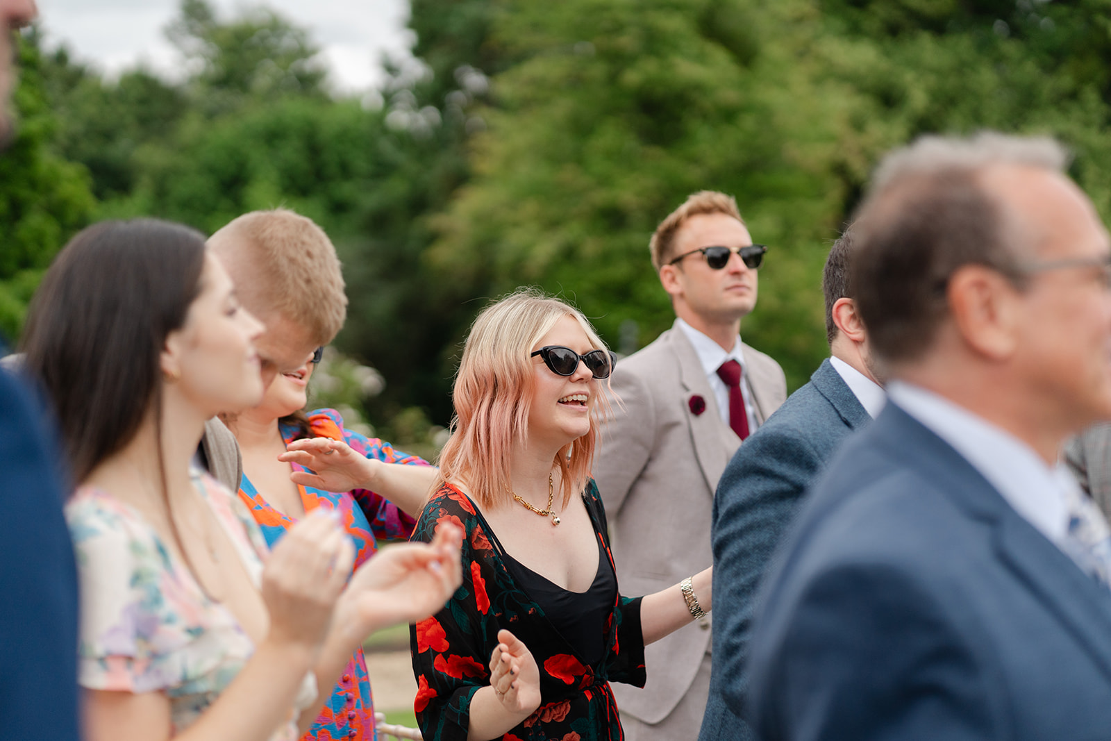wedding guests look surprised and happy as they clap hands to music