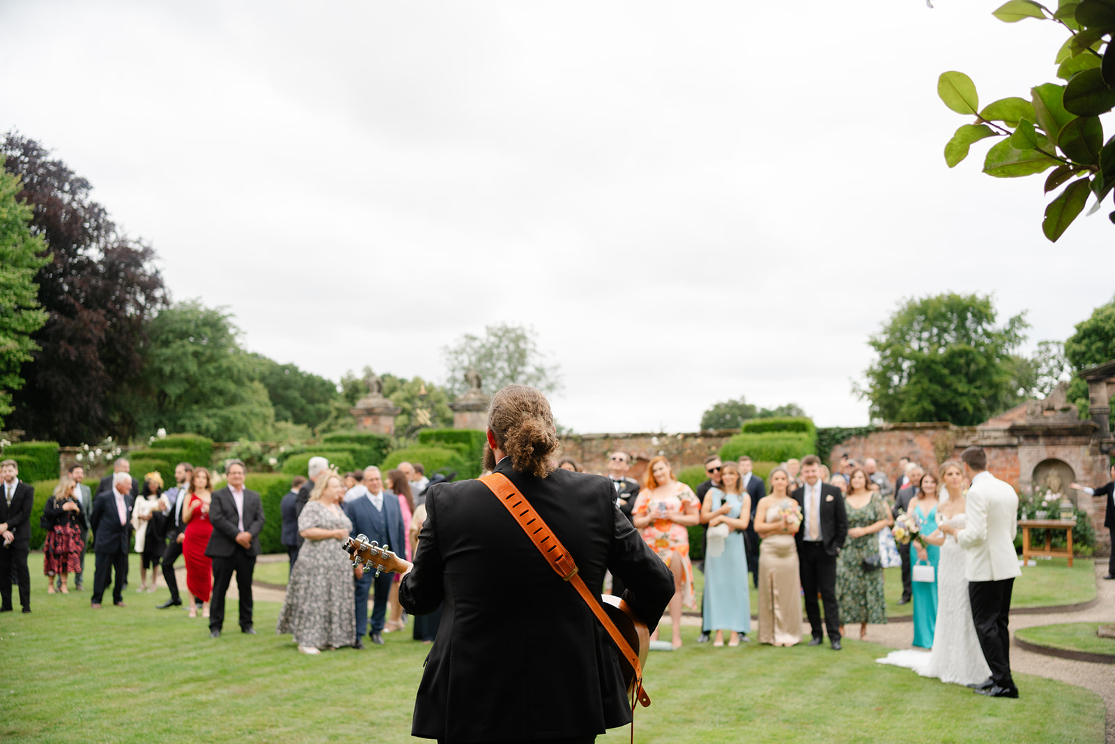 reaction of guests as they watch groom's brother play guitar and sing
