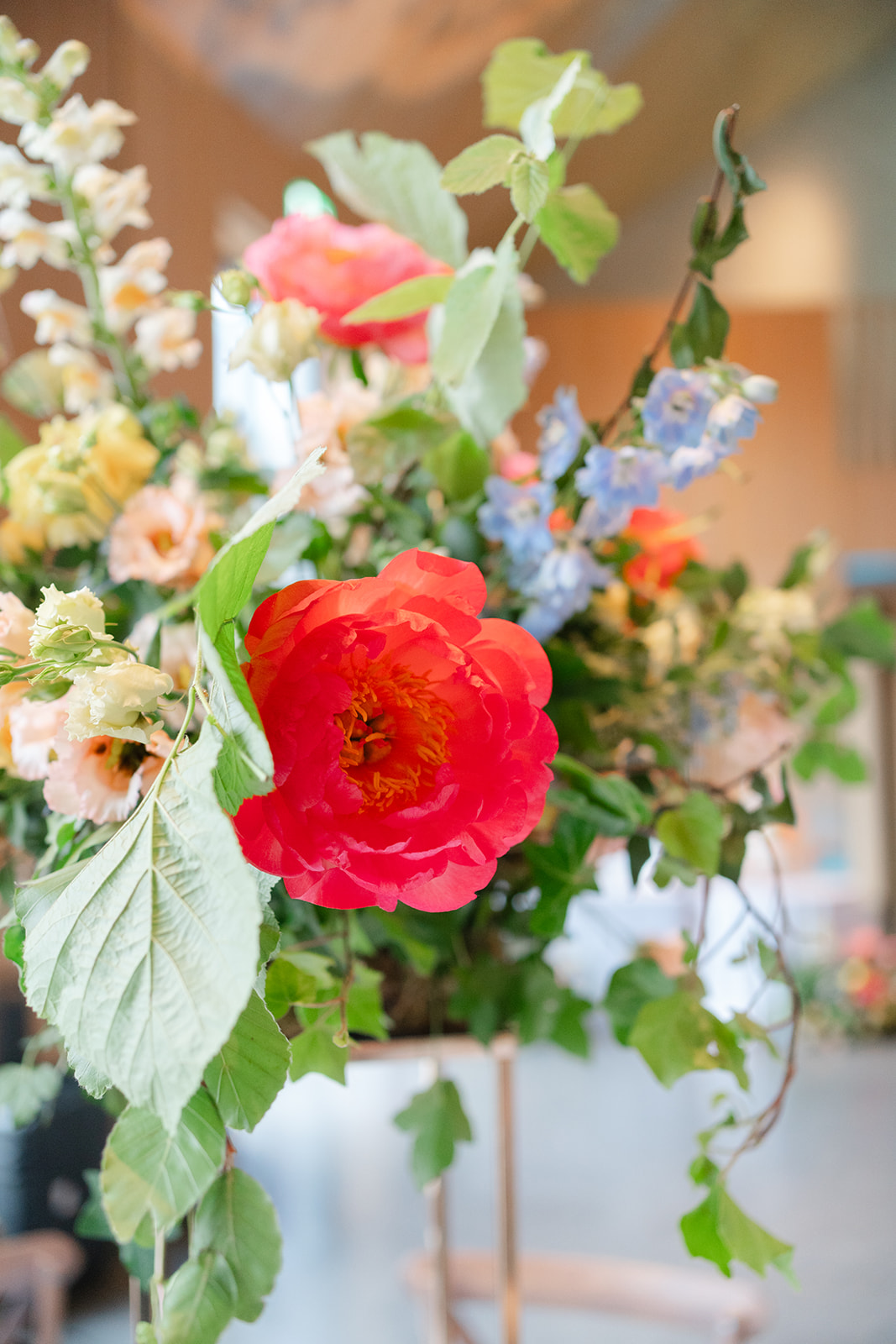 close up of wedding centrepiece with bright colours, corals, pinks, yellows and blues