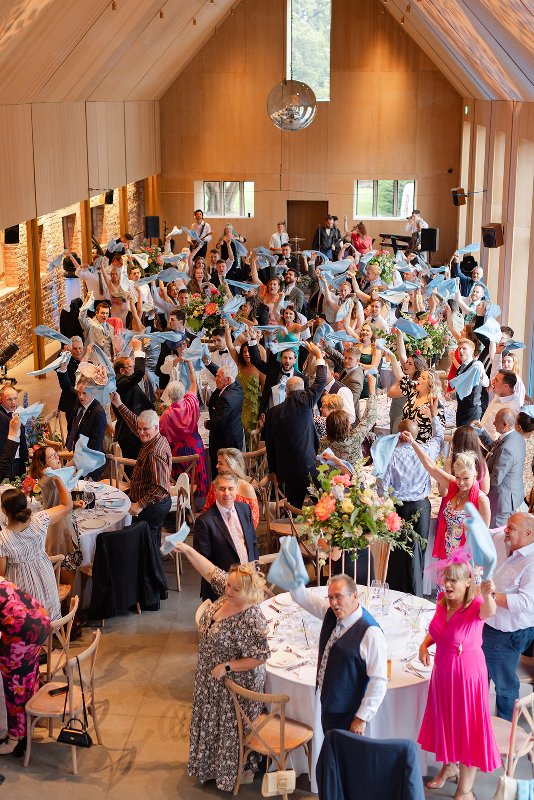 Arial photo of all the guests at the tables, standing and waving napkins