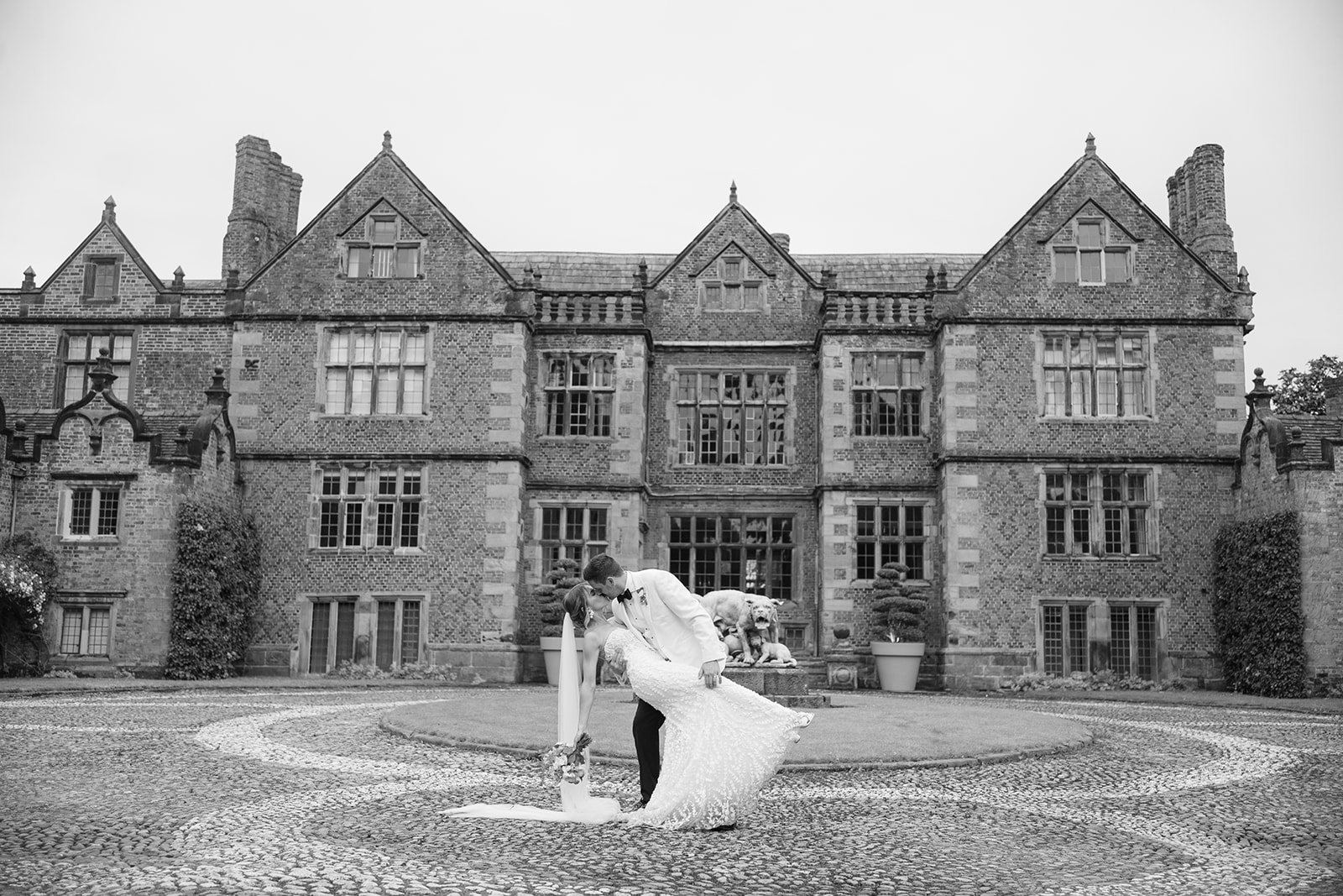 bride and groom in front of Dorfold hall wedding venue performing a 'dip'