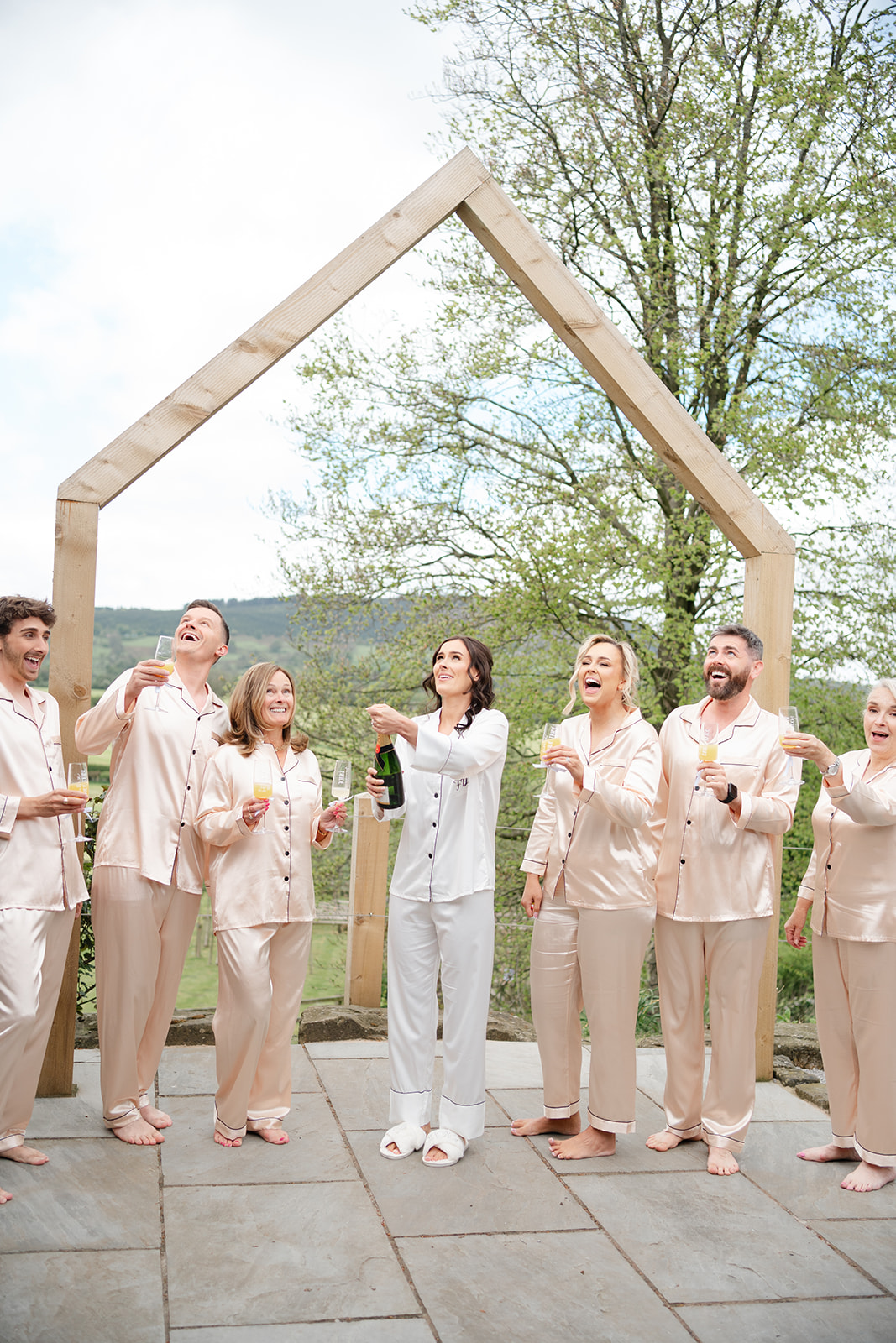bride and bridal party pop champagne at bashall barn