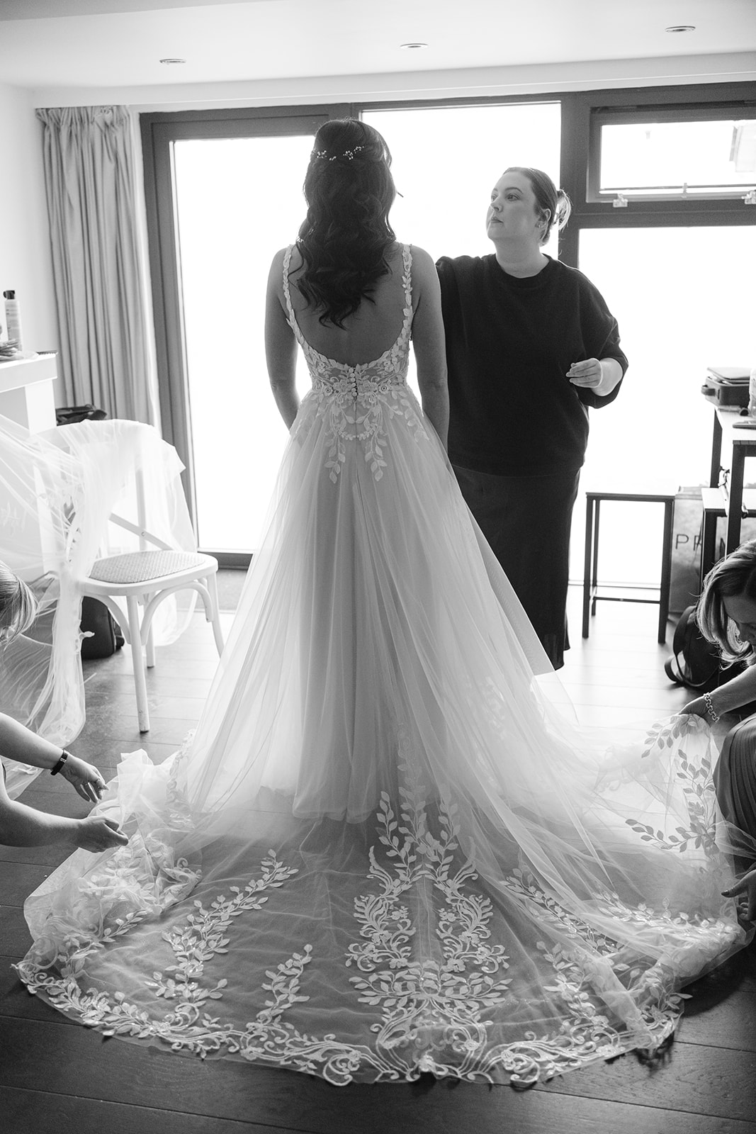 black and white photograph of bride from behind, showing long, lace train.