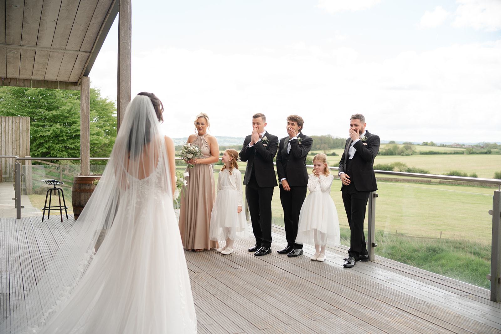 dress reveal with bridal party on the balcony at Bashall Barn