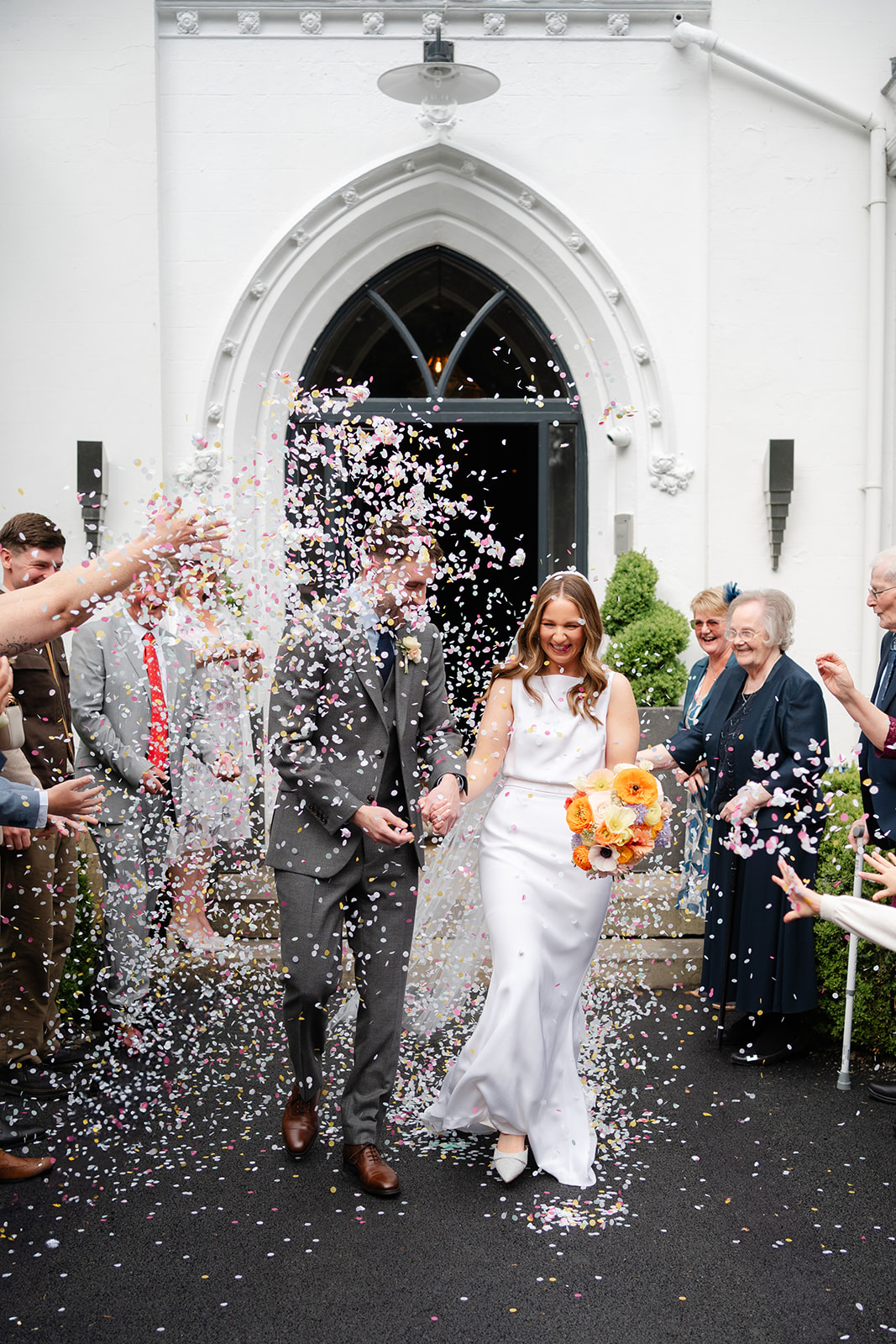 bride and groom are showered with confetti at Didsbury House Hotel