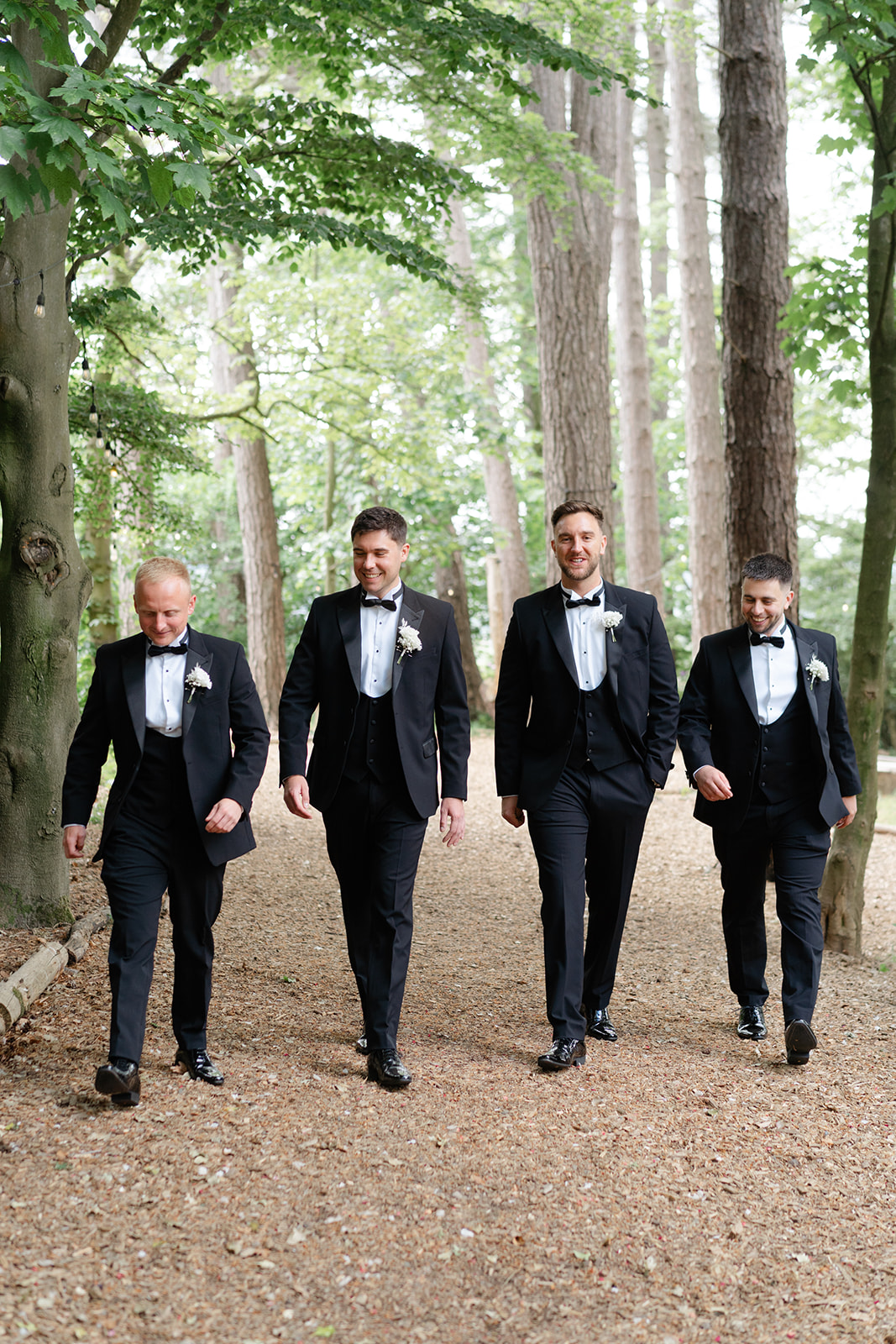 groom and groomsmen walk through the woods at hobbit hill