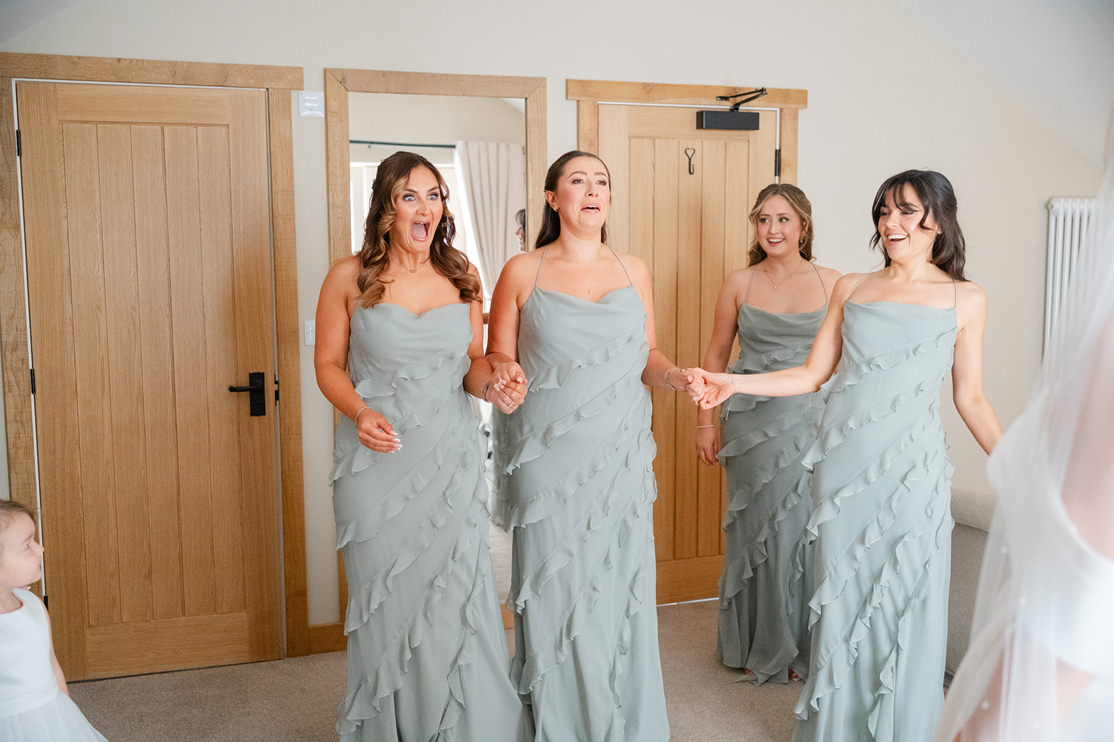 bridesmaids react with screams and smiles to seeing the bride for the first time