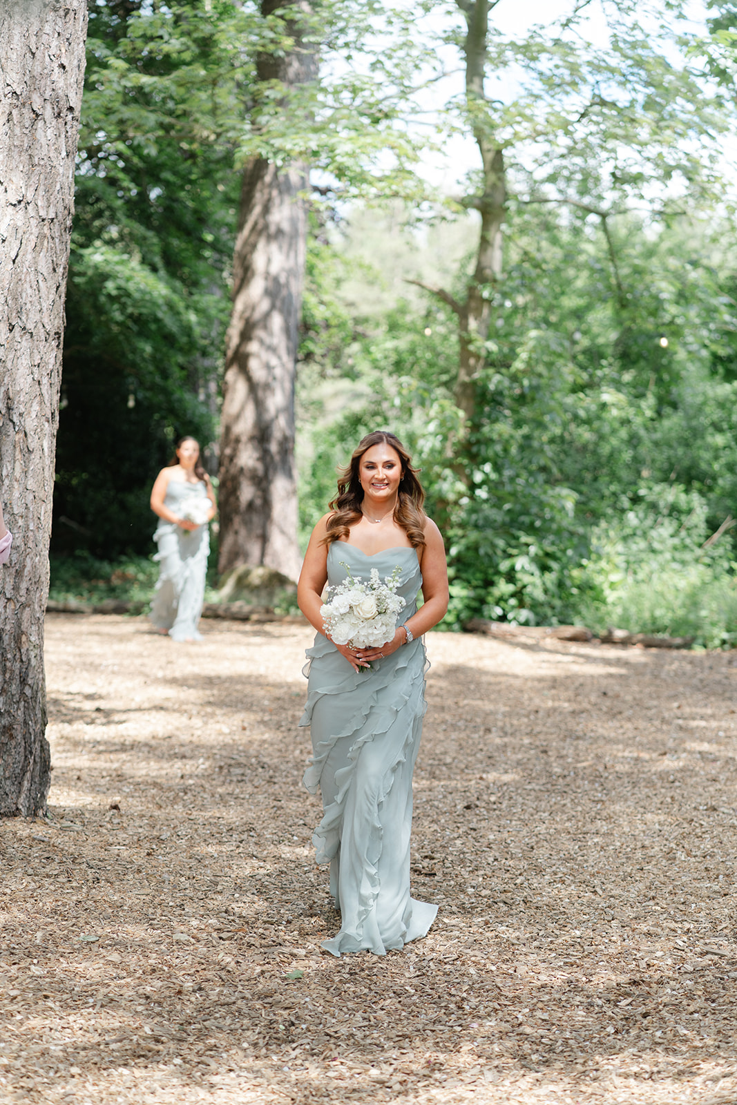 bridesmaid in sage green walking down the aisle