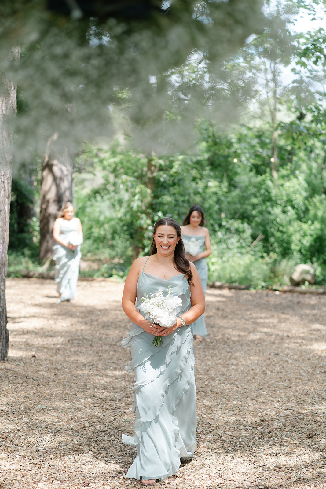 bridesmaid in sage green walking down the aisle